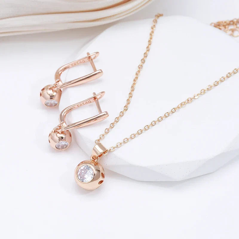 Close-up of a stunning women's rose gold zircon jewelry set with orb earrings and an elegant necklace.