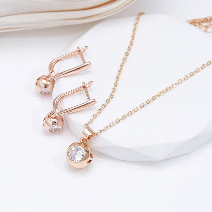 Close-up of a stunning women's rose gold zircon jewelry set with orb earrings and an elegant necklace.