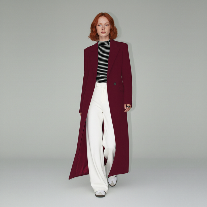 Woman wearing a ruby longline tailored coat, elegant and fitted for a classic evening look.