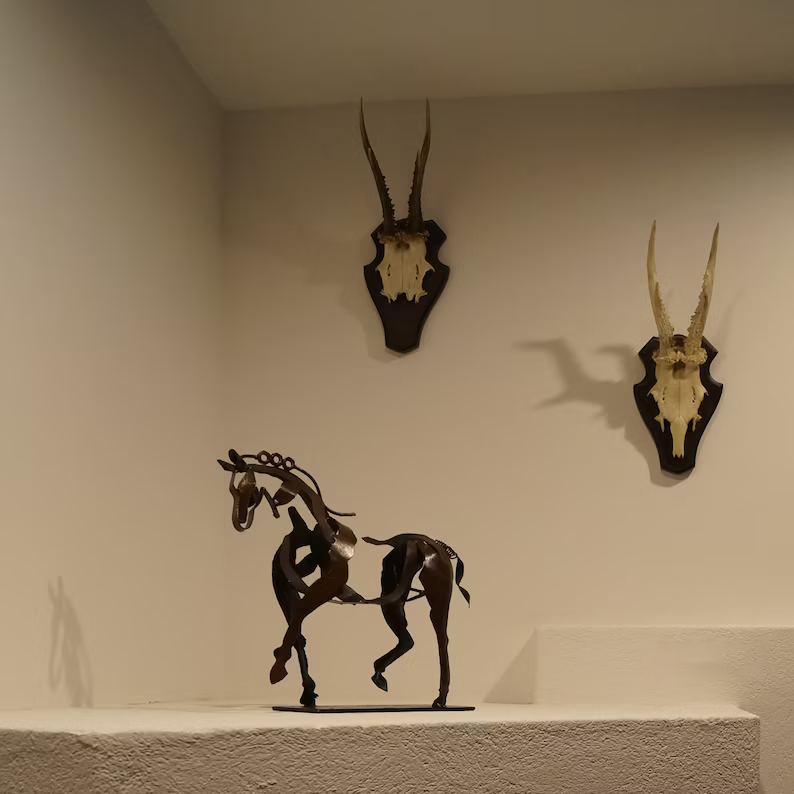 Decorative metal horse sculpture, rustic style. Handcrafted animal figurine, ideal for living room or office decor.