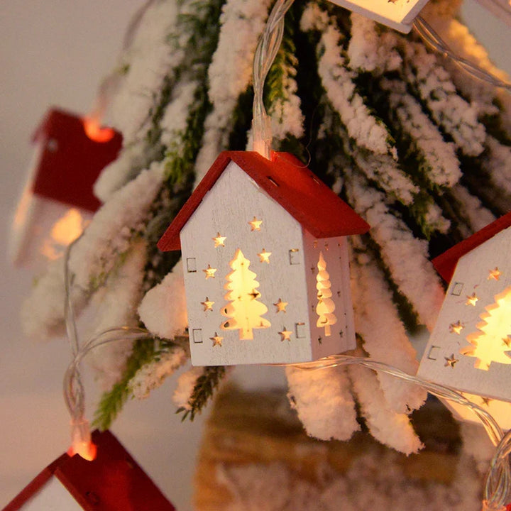 Set of miniature wooden Christmas houses, each with a warm LED glow. Rustic holiday ornaments.