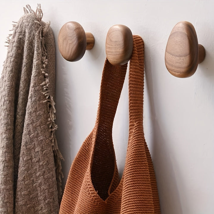 Handcrafted natural wood pebble wall hooks, a stylish and modern addition to any home's wall decor.