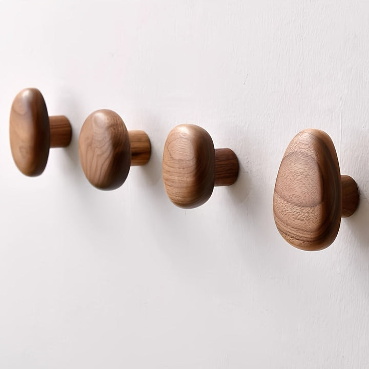 Multiple natural wood pebble wall hooks, a decorative set for coat hanging, towels & modern home organization.