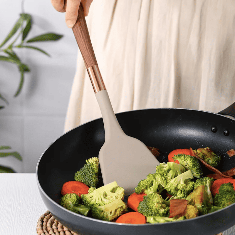 Ergonomic silicone and wooden handle utensil set for modern kitchens, complete cooking tools.