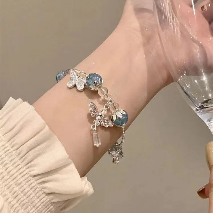 Sky blue butterfly & floral bracelet for women. Handcrafted summer jewelry with delicate lilac accents. Perfect gift.