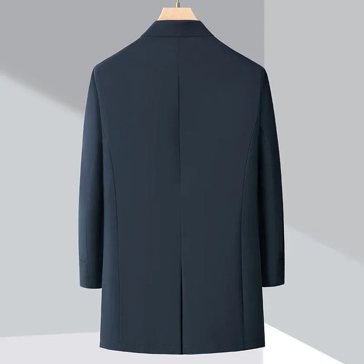 Modern men's blue insulated trench coat, ideal for cold weather urban commutes and sleek fall fashion outerwear.