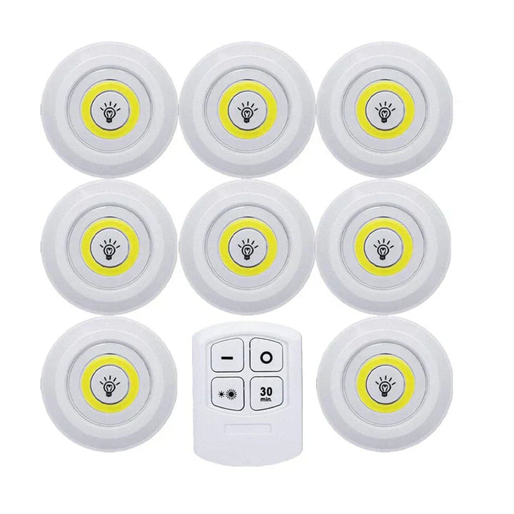 Smart LED puck lights mounted inside a dark display cabinet, highlighting decorative items