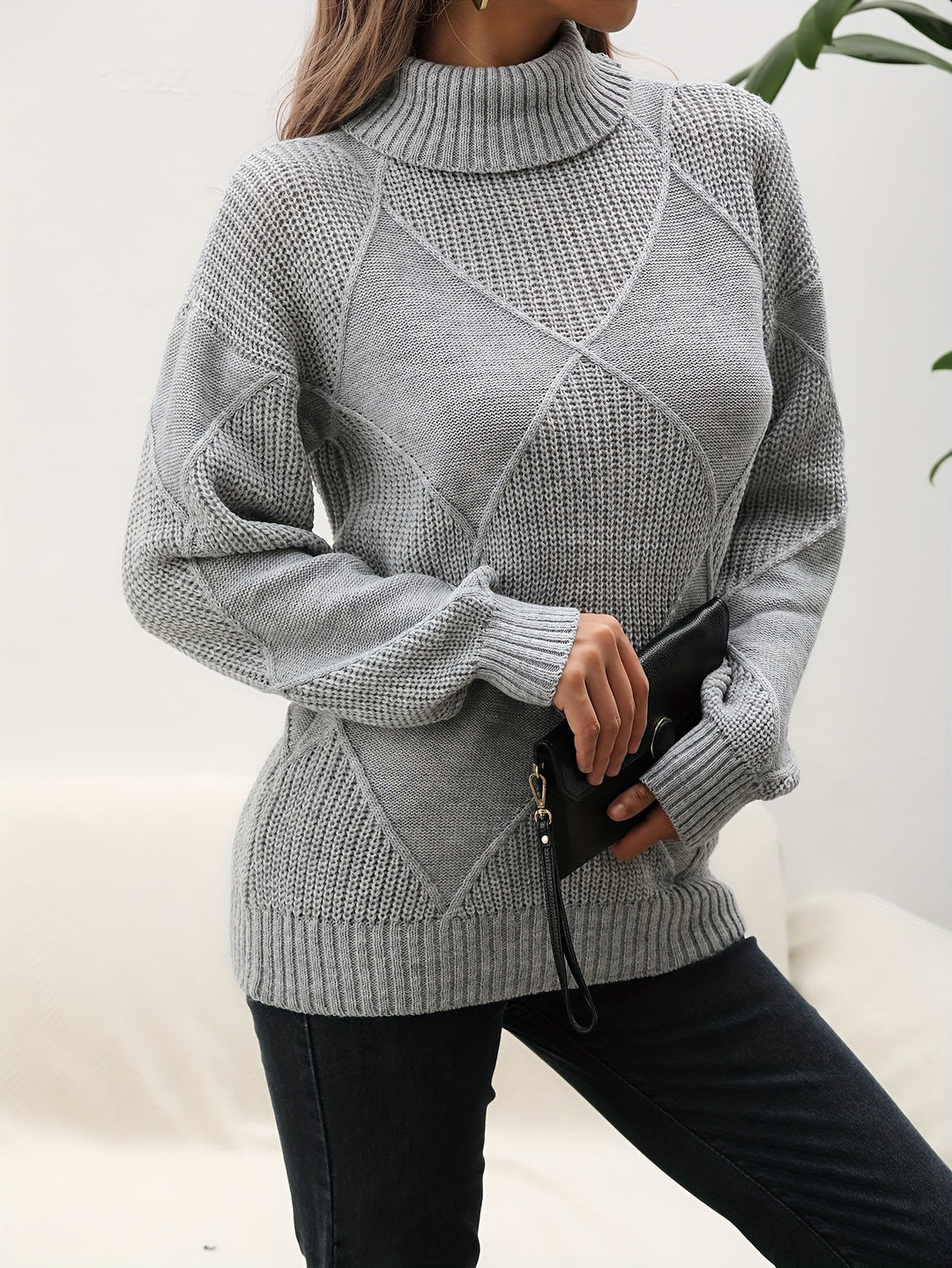 Women's soft knit turtleneck sweater with dropped shoulders. Perfect cozy top for winter and autumn fashion.