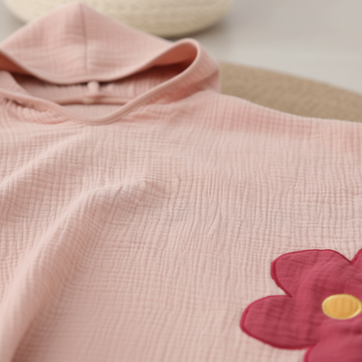 Close-up of a soft, quick-dry cotton muslin hooded poncho, ideal for children's bath wraps