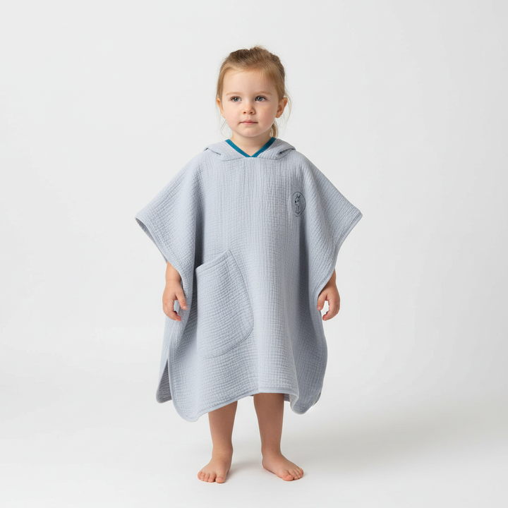 Stack of colorful muslin hooded ponchos, essential quick-dry cotton towels for kids' bath and swim