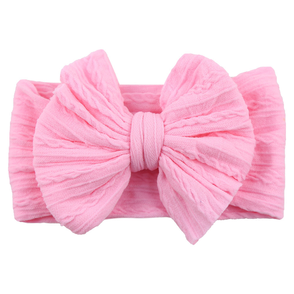 Baby accessory: yellow nylon bow headband on a white background, cute design.