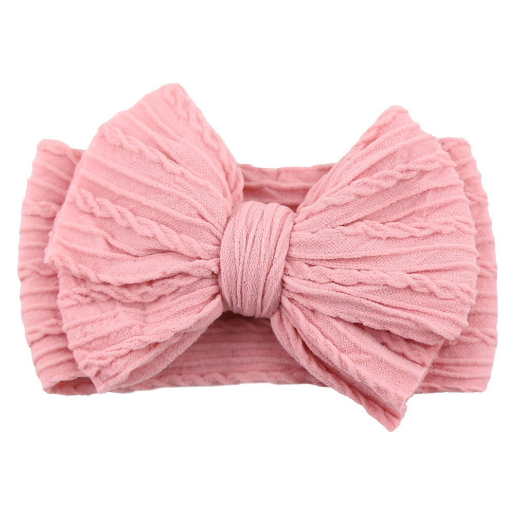 Little girl with a green nylon bow headband, a beautiful children's fashion piece.