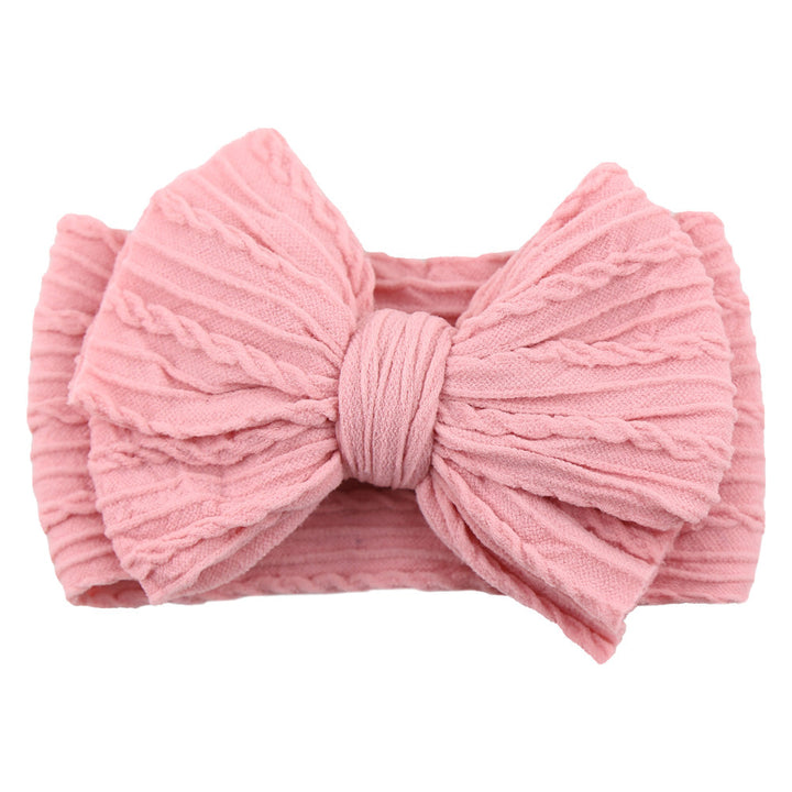 Little girl with a green nylon bow headband, a beautiful children's fashion piece.