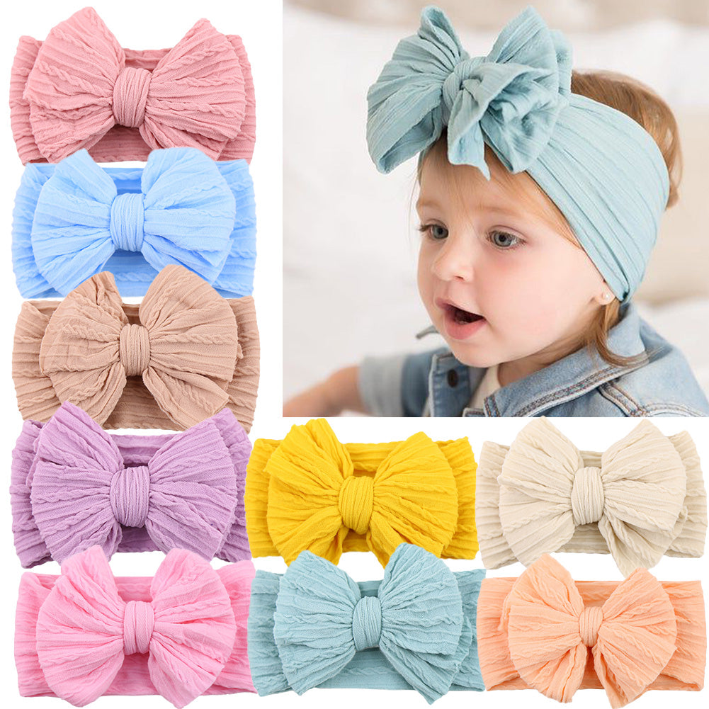 Baby wearing a gentle white nylon bow headband, perfect infant fashion.