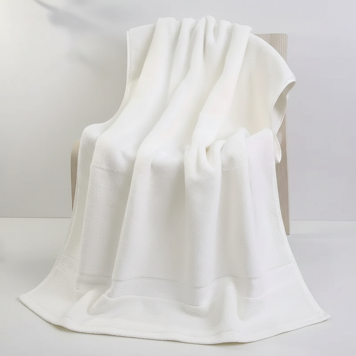 Stack of multiple Quick-Dry cotton bath towels, indicating bulk availability and comfort