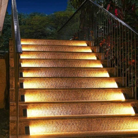 Weather-resistant solar step light casting bright LED illumination on stairs