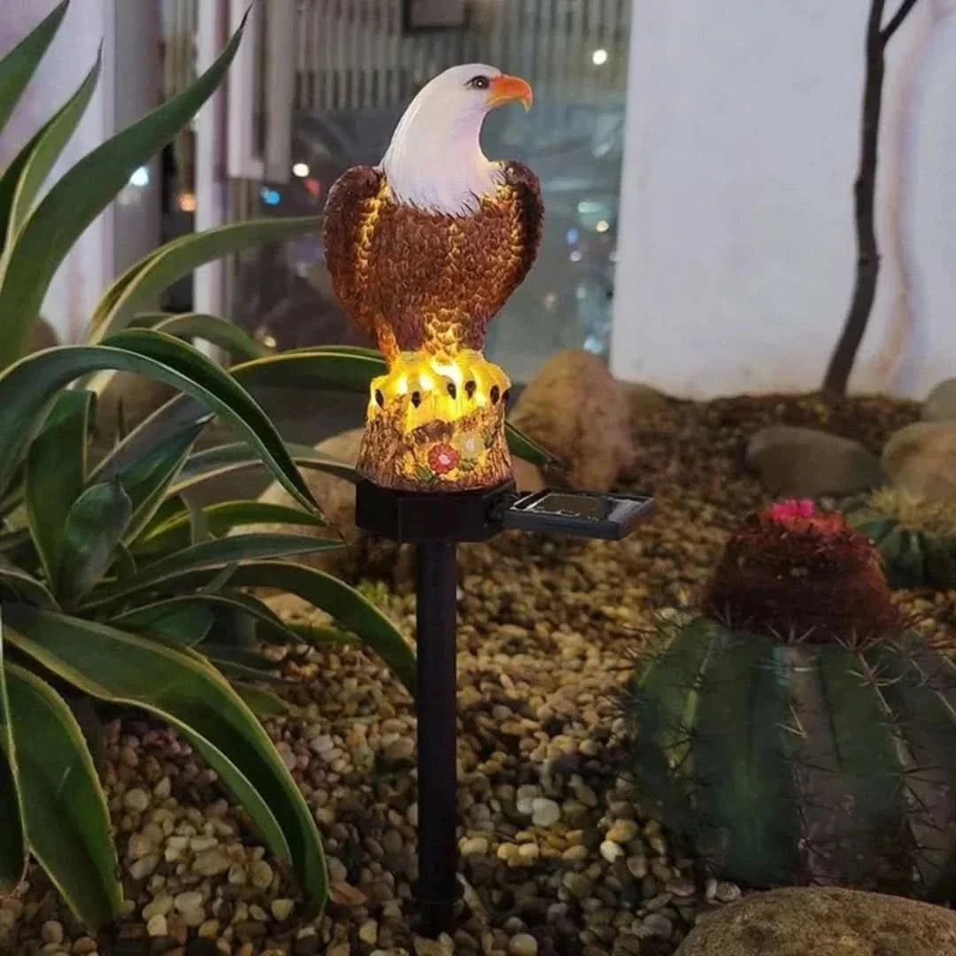 Weather-resistant NightPerch solar animal garden stake light illuminating a garden pathway at dusk.