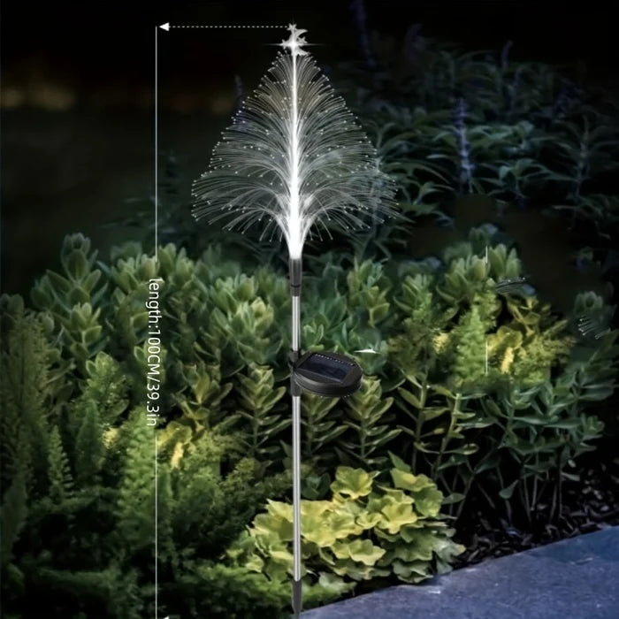 Illuminated solar Christmas tree lights adorning a garden, enhancing outdoor holiday decor.