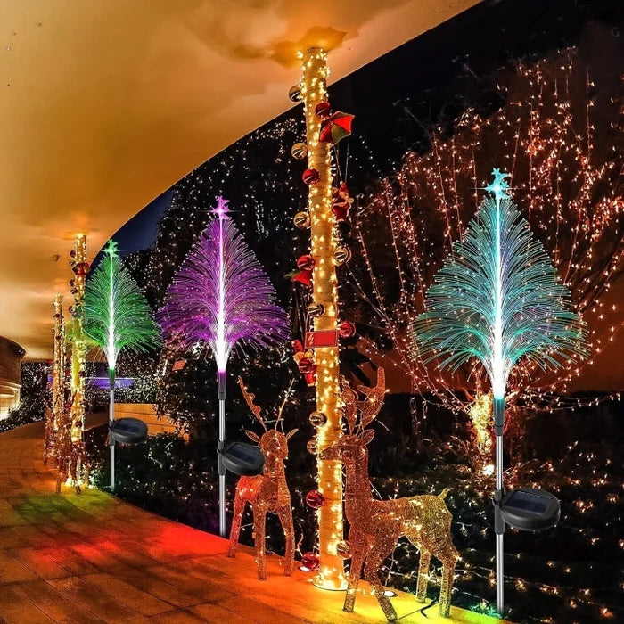 Multiple solar Christmas tree lights brightening a garden path, ideal for festive landscape lighting.