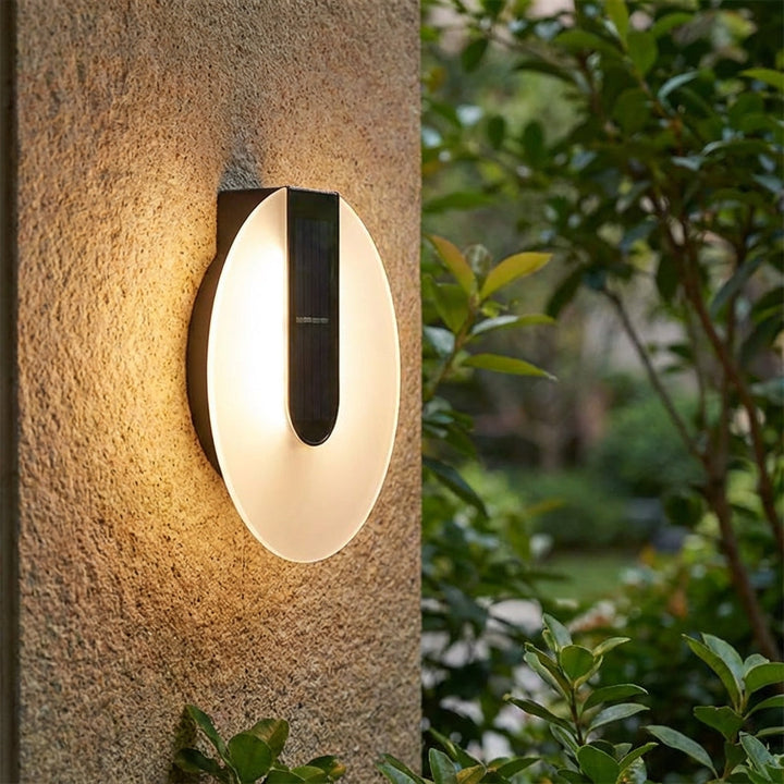 Solenyx modern round LED outdoor wall sconce, weatherproof, illuminating a patio
