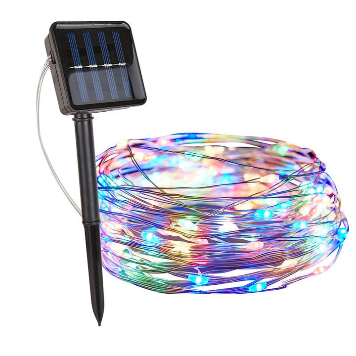 SoliGlow LED string lights, solar powered, creating a magical atmosphere for an outdoor party.