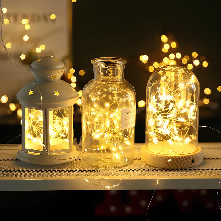 Waterproof SoliGlow solar fairy lights draped over a patio umbrella, perfect for parties.