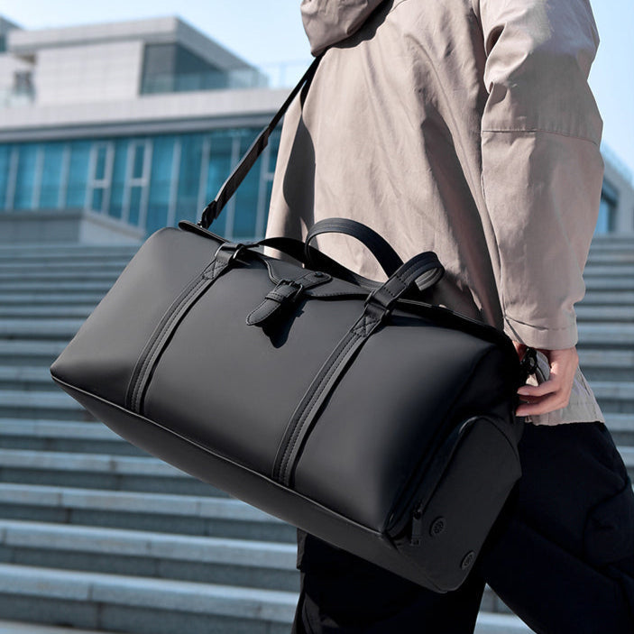Black unisex duffle bag, spacious design ideal for travel, weekend trips, or gym, featuring shoe compartment.