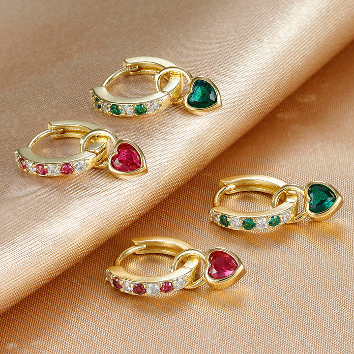Close-up of sparkling heart earrings, showcasing intricate zircon details and a lustrous gold finish.