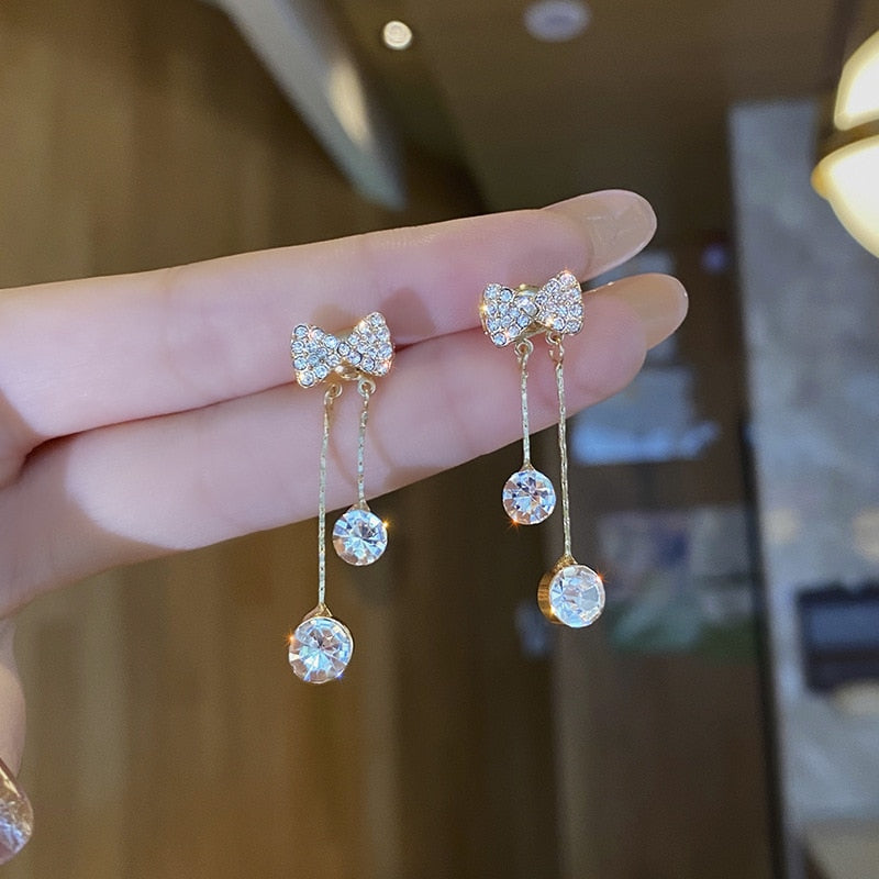 Detailed view of women's silver tone rhinestone dangle earrings, shimmering design.