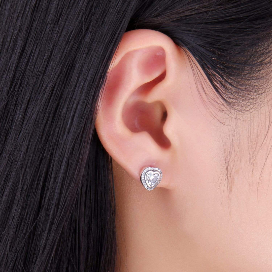 Women's elegant silver heart earrings featuring shimmering zirconia stones. A beautiful jewelry piece.