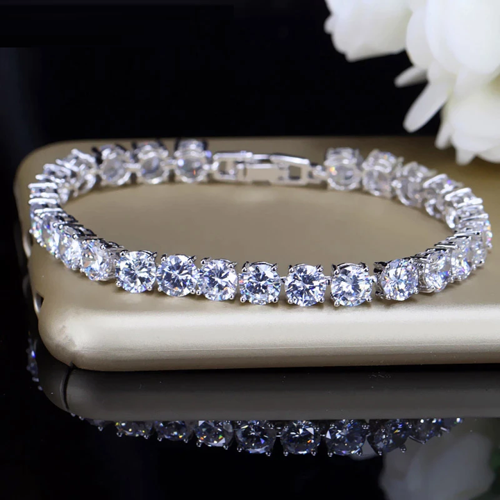 Sparkling women's crystal heart tennis bracelet; elegant silver-tone adjustable fashion accessory.