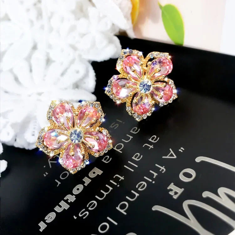 Close-up of women's delicate floral stud earrings, featuring shimmering zirconia petals set in sterling silver.