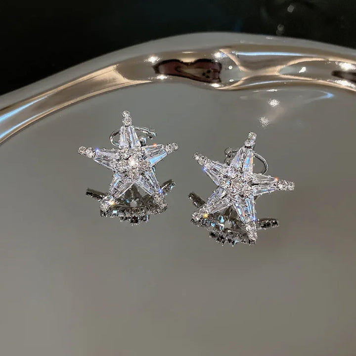 Close-up of women's silver zirconia star earrings and ear cuff. Celestial jewelry, adding a sparkling, versatile touch.