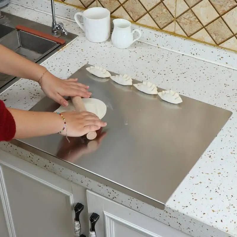 Hygienic stainless steel cutting board, durable for kitchen food prep. Features non-slip design and integrated lip.