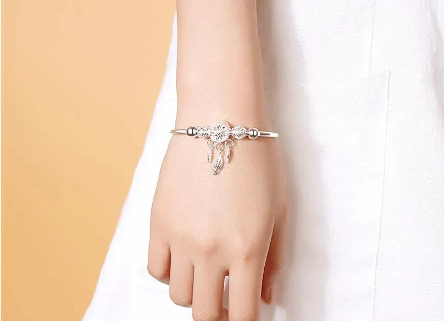 Women's bohemian sterling silver dreamcatcher bracelet, promoting positivity & unique style.