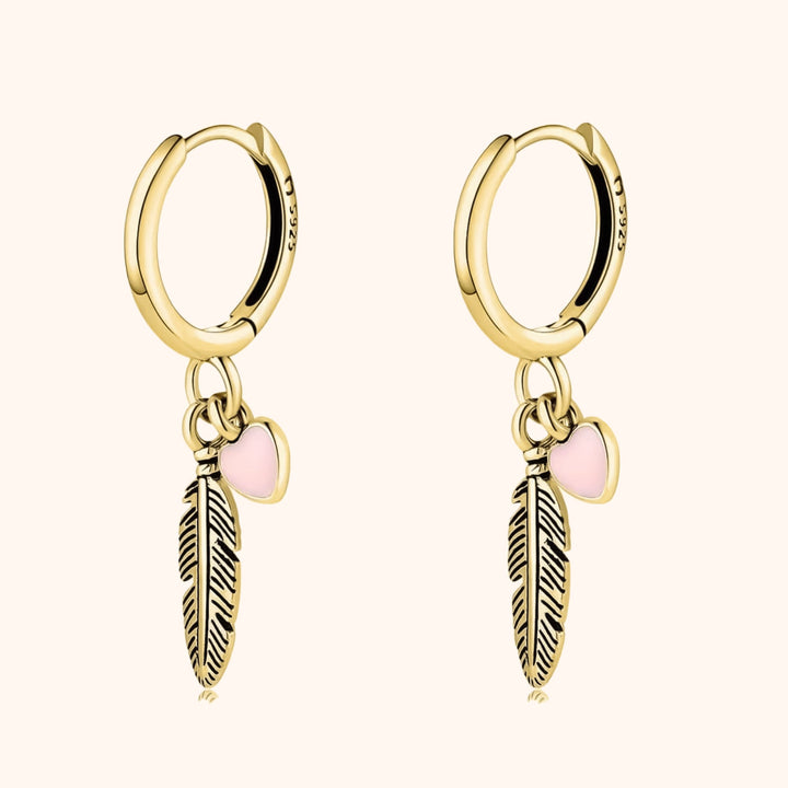 Delicate sterling silver hoop earrings, adorned with a charming feather and heart. Stylish women's feather & heart jewelry.