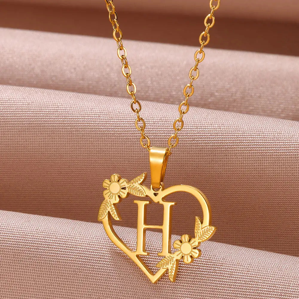 Woman wearing a delicate sterling silver personalized heart initial necklace, a beautiful custom jewelry fashion accessory.