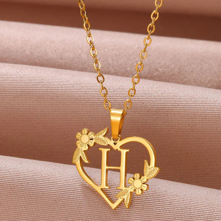 Woman wearing a delicate sterling silver personalized heart initial necklace, a beautiful custom jewelry fashion accessory.