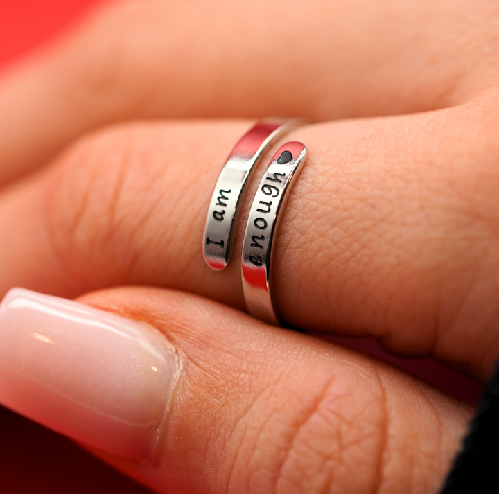 Close-up of women's sterling silver 'I Am Enough' affirmation ring. Promotes self-love & mental health empowerment.