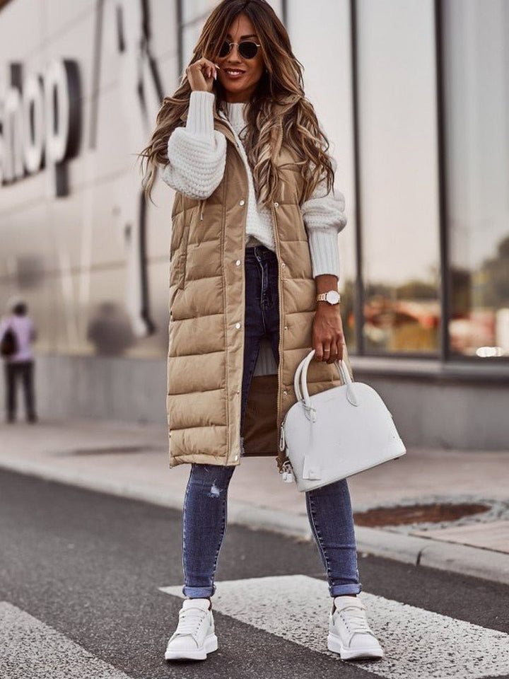 Chic beige knee-length padded gilet for women, cozy winter outerwear.