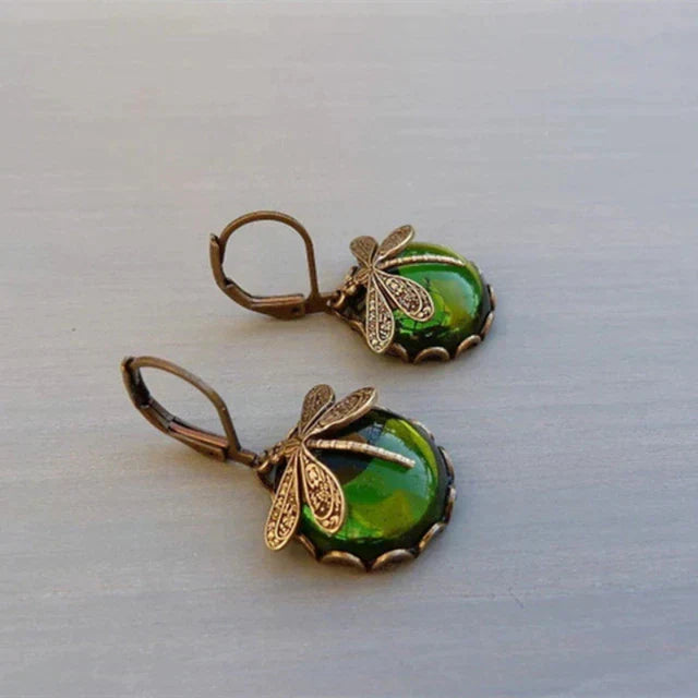 Shimmering crystals set in stylish antique gold drop earrings, luxurious women's elegant jewelry.