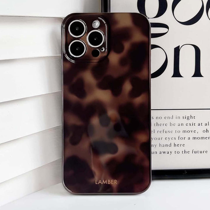 Stylish tortoiseshell glass iPhone case, slim, shockproof, and scratch-resistant for optimal protection.