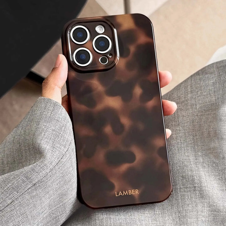Elegant tortoiseshell pattern glass iPhone case, a stylish accessory providing durable device protection.
