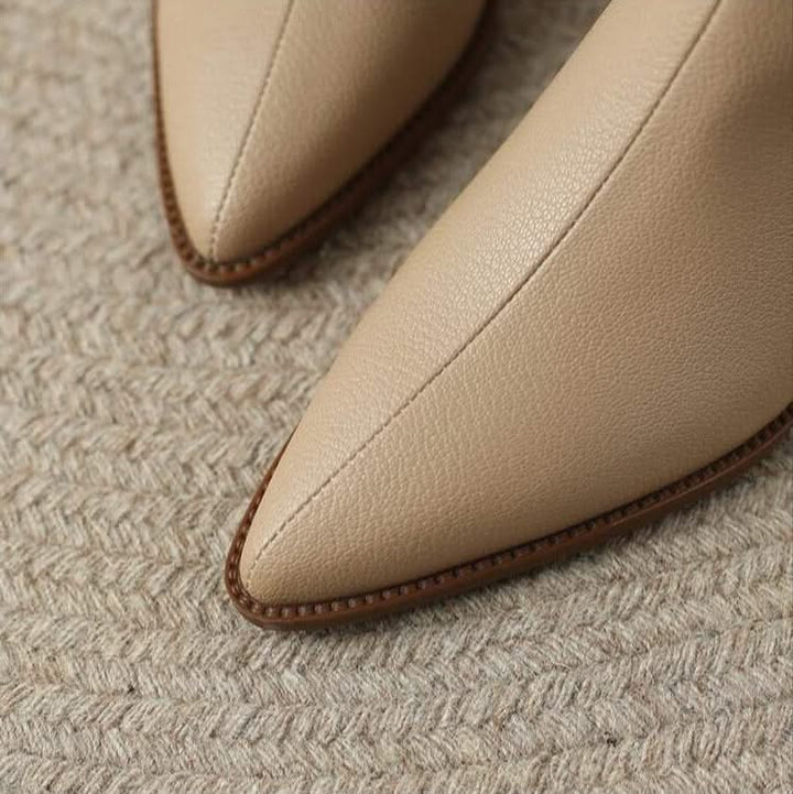 Classy women's pointed toe ankle boots on a model, showcasing elegant low heel and sleek design.