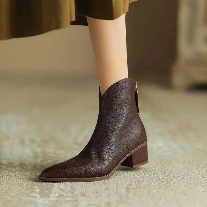 Women's elegant black ankle boots featuring a sleek pointed toe and comfortable low heel for winter.