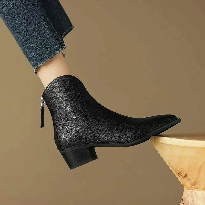 Zip closure detail on women's sophisticated black pointed toe ankle boots, blending style & convenience.