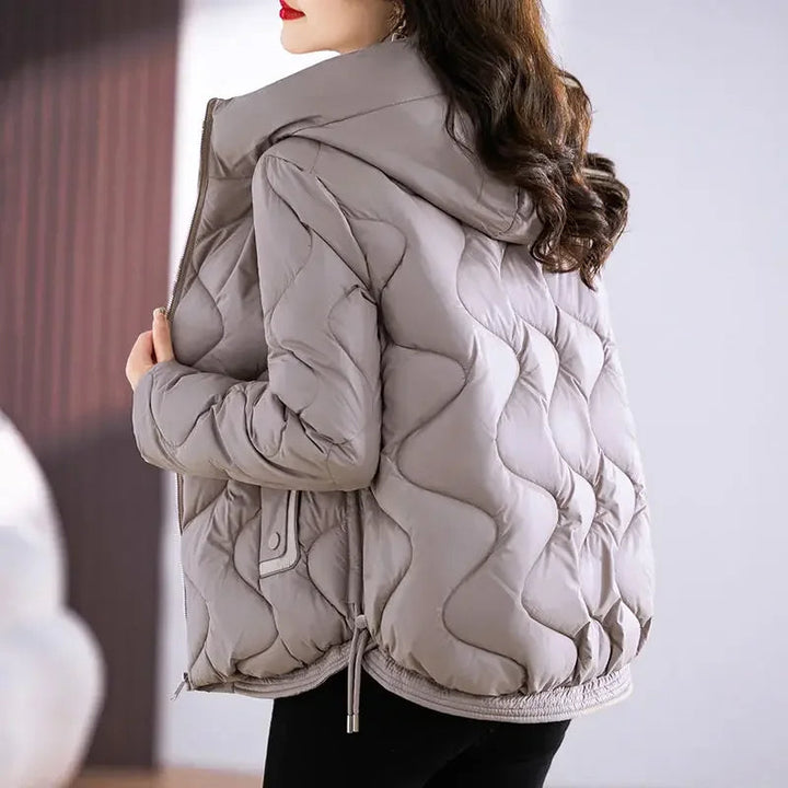 Woman models a cozy, water-resistant puffer jacket, ideal for cold weather & outdoor activities.