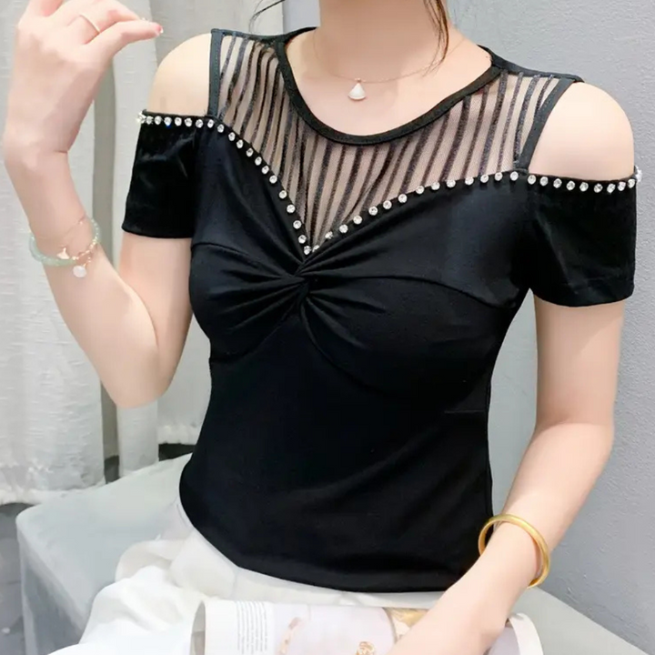 Trendy black cold-shoulder top for women. Elegant design with comfortable, versatile wear.