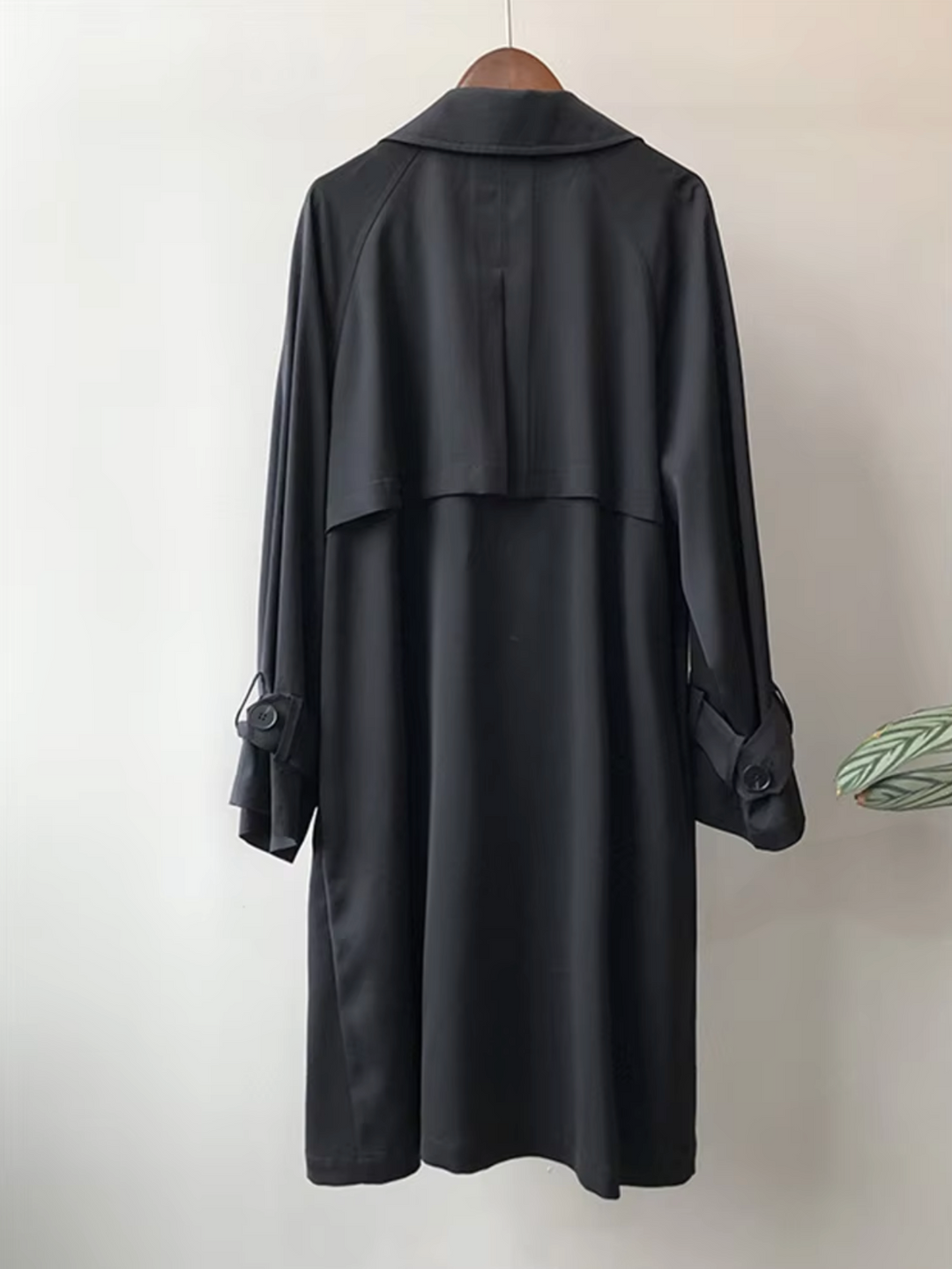 Modern women's double-breasted trench coat with wide lapels, offering a sleek, waterproof, and stylish look for work.