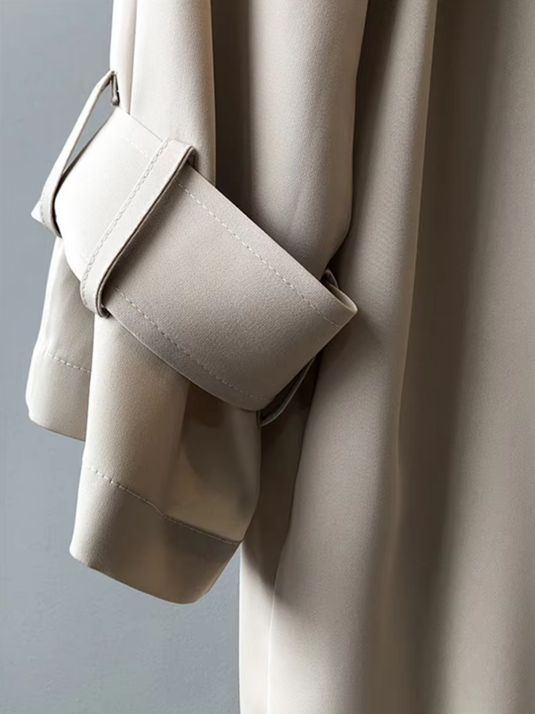 Full-length shot of a chic women's waterproof trench coat, featuring a double-breasted front for classic, stylish outerwear.
